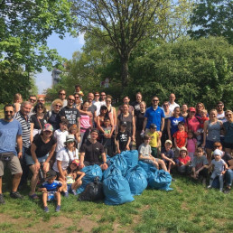 Plogger-Gruppe ausfrauen, Männern und Kindern posiert mit vollen Abfallsäcken für Gruppenfoto